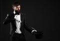 Male magician showing tricks on dark background Royalty Free Stock Photo