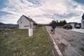 A male man with a german shepherd dog is walking on the side of the road in a country side. Rear view. a loyal friend of man. Royalty Free Stock Photo