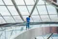 Male man on glass bridge looking down in futuristic interior, steel glass wall, panoramic window