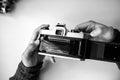 Male man hands reloads film in pentax retro camera on a white table