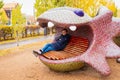 Male man sitting on large lizard sculpture bench, landscape decor design, park recreation area. Close-up. Astana Nur-Sultan,