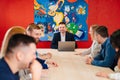 The male manager holds a meeting for subordinates in the meeting room.