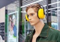 Male mannequin in work clothes with yellow anti-noise headphones on his head