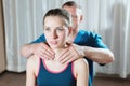 Male manual visceral therapist masseur treats a young female patient. Warm up the shoulders and neck