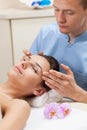 Male masseur massaging female head