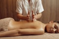 Male masseur pampering back to young woman