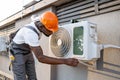 Male master fixing conditioner and checking fan outdoors Royalty Free Stock Photo