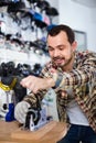 Male master fixing roller-skates in sports store