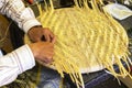Male master hands weaves straw hat.