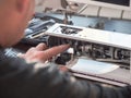 Male master repairs the sewing machine. Professional adjustment of a sewing machine in a small factory. Cleaning and repair of