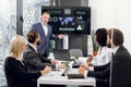 Male mature manager in business suit, speaking at office meeting with his multiethnic male and female colleagues Royalty Free Stock Photo