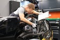 Male mechanic diagnoses parts on motorcycle at service center
