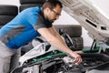 Male mechanic examining and maintenance to customer the engine. Open vehicle car hood. Safety inspection test engine.