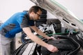 Male mechanic examining and maintenance to customer the engine. Open vehicle car hood. Safety inspection test engine.