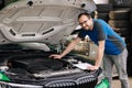 Male mechanic examining and maintenance to customer the engine. Open vehicle car hood. Safety inspection test engine.