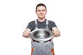 Male mechanic in gray uniform holds brake disk in hands. Royalty Free Stock Photo