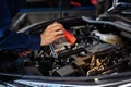 Male mechanic holding and shining flashlight to checking car engine problem Royalty Free Stock Photo