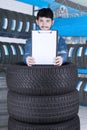 Male mechanic holds empty clipboard in workshop Royalty Free Stock Photo