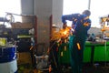 Male mechanic working tool Angle grinder in the garage for car repairs. Sparks fly out of under the metal part. Concept theme