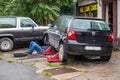 Male mechanic working under car at a small car service