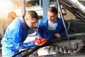 Male mechanics fixing car in service center Royalty Free Stock Photo