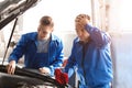 Male mechanics fixing car in service center Royalty Free Stock Photo