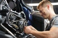 Male mechanik repair motorcycle in special service portrait.