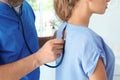 Male medical assistant examining female patient