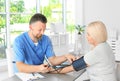 Male medical assistant measuring female patient