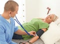 Male medical assistant measuring female patient blood Royalty Free Stock Photo