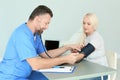 Male medical assistant measuring female patient Royalty Free Stock Photo