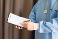 Male medicine doctor hand holding pen writing something on clipboard closeup. Medical care, insurance, prescription, paper work o Royalty Free Stock Photo