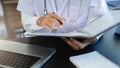 Male medicine doctor hand holding pen writing something on clipboard close up. Ward round, patient visit check, medical Royalty Free Stock Photo