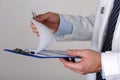 Male medicine doctor hand holding silver pen looking in clipboard closeup Royalty Free Stock Photo
