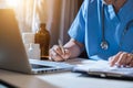 Male medicine doctor hand holding silver pen writing something on clipboard closeup. Royalty Free Stock Photo