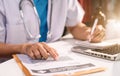 Male medicine doctor, physician or practitioner in lab room writing on blank notebook.