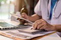 Male medicine doctor, physician or practitioner in lab room writing on blank notebook and work on laptop computer. Royalty Free Stock Photo