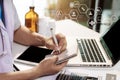 Male medicine doctor, physician or practitioner in lab room writing on blank notebook and work on laptop computer. Royalty Free Stock Photo