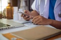 Male medicine doctor, physician or practitioner in lab room writing on blank notebook and work on laptop computer. Royalty Free Stock Photo