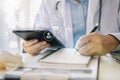 Male medicine doctor, physician or practitioner in lab room writing on blank notebook and work. Royalty Free Stock Photo