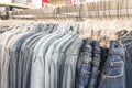 Male mens denim jeans shirts sorted on clothes hangers on a shop wardrobe closet rail