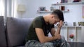 Male military praying, holding wooden cross in hand, remembering dead comrade Royalty Free Stock Photo