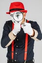 Male mime looking through the magnifying glass. isolated on white background