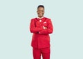 Happy handsome young man in red suit standing with arms folded in fashion studio Royalty Free Stock Photo