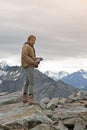 Male model posts at the top of snowcapped mountain peak around Aoraki Mount Cook and Mount Cook National Park