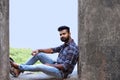 Male model sitting on a rock ledge looking at camera, Sion fort, Mumbai Royalty Free Stock Photo