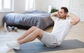 Sporty Man Doing Sit-Ups Abs Exercise On Mat In Bedroom Royalty Free Stock Photo