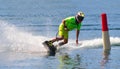Male Motosurf Competitor Taking corner at speed creating a lot of spray.