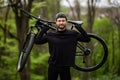 Male mountain biker carrying bicycle in the forest on a sunny day Royalty Free Stock Photo