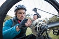 Male mountain biker fixing his bike chain